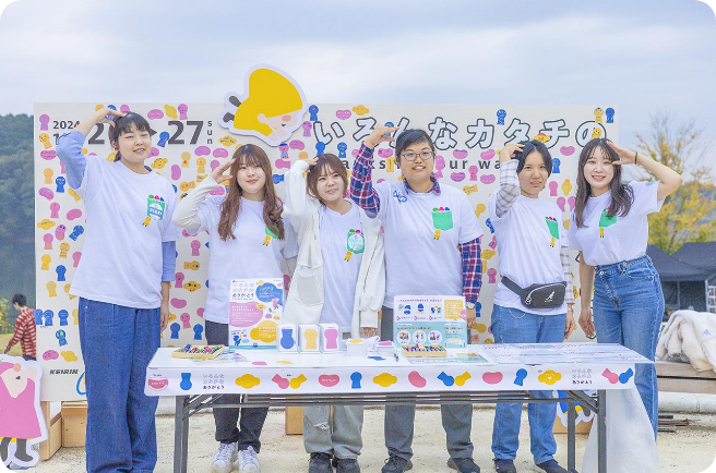 展示ブースの前でポーズを取るトントゥサポーターの集合写真